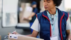 african-american-worker-organizing-delivering-schedule-checking-boxes-before-delivery-her-colleague-is-loading-packages-van-background_637285-1254